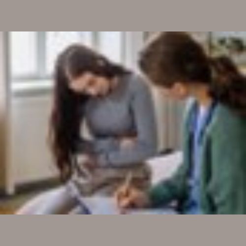 A patient holding her stomach and a healthcare professional taking notes on her clipboard