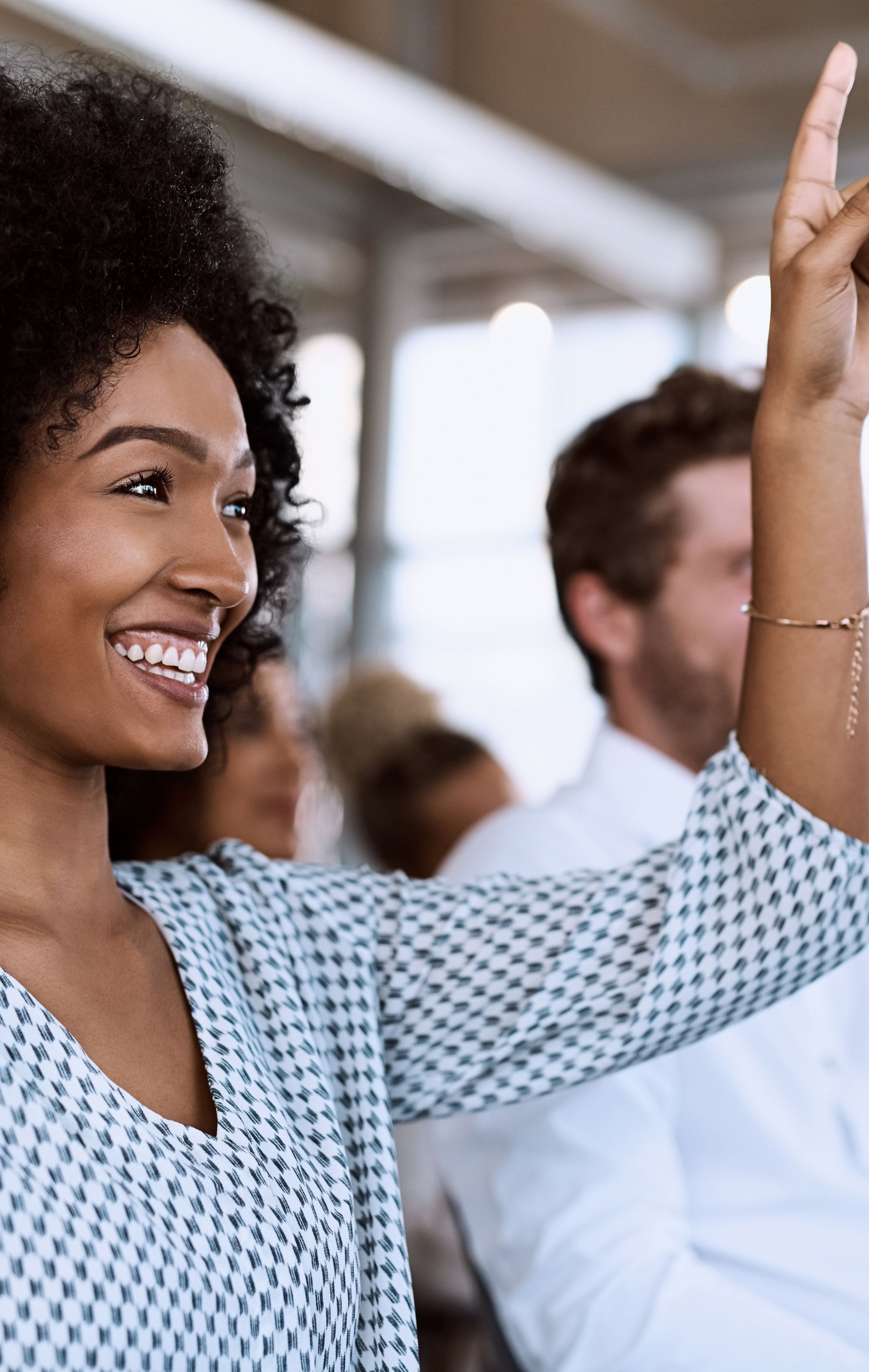 Woman with hand raised to answer a question