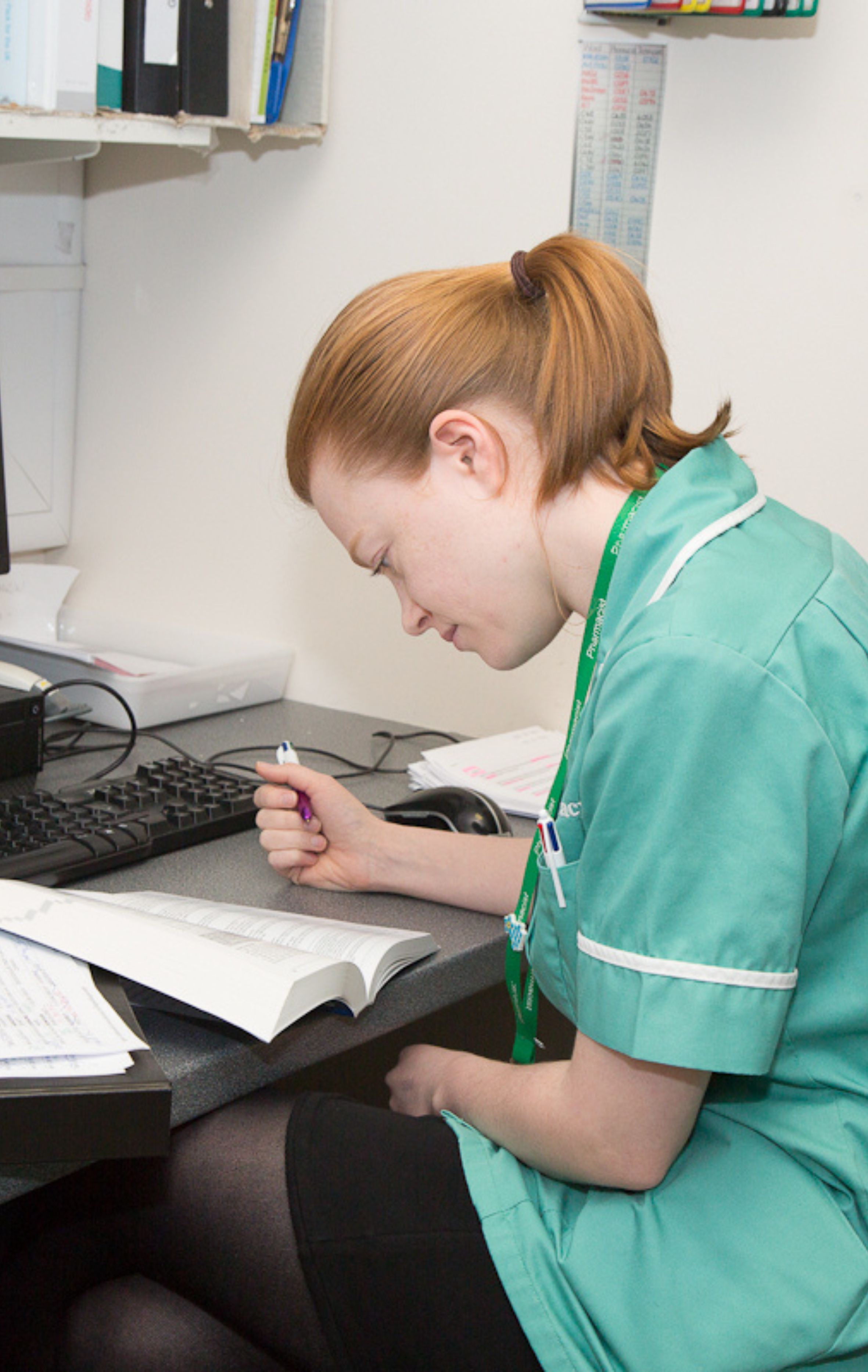 pharmacy professional at a desk reading through her notes