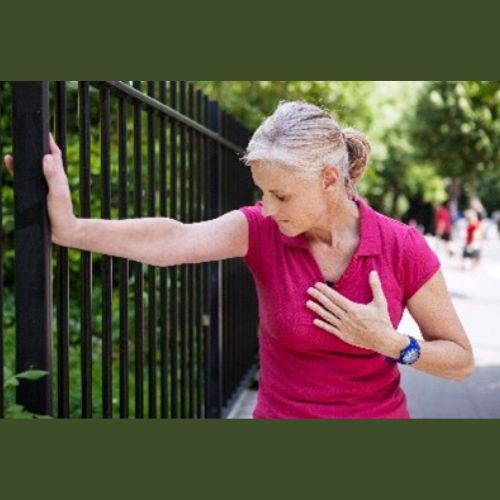 a lady standing outside, clutching at her chest