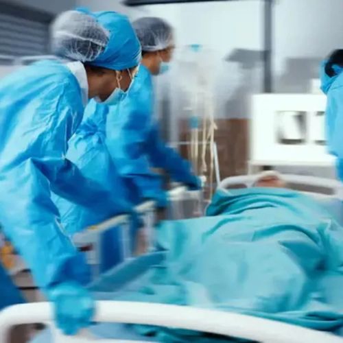 Medical team moving a patient on a hospital bed