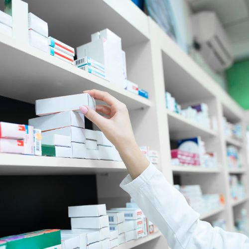hand taking box of tablets off a shelf