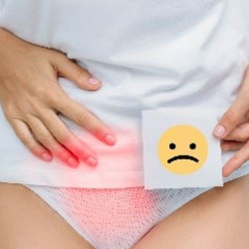 person holding a picture of a sad face smiley with a red highlight over the urogenetal area.