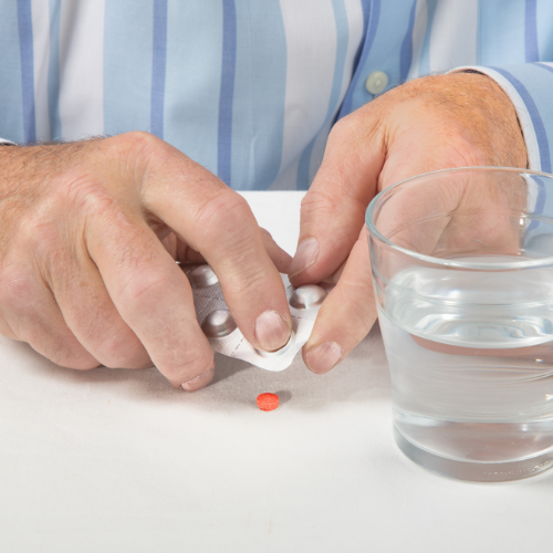 Person taking a red tablet out of its packaging
