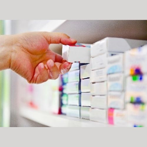a hand picking a box of tablets from a shelf