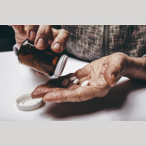 person taking tablets out of a bottle