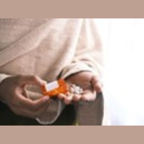 a person taking tablets from a tablet bottle