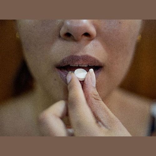 lady putting a tablet in her mouth
