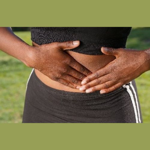 A lady with her hands on her abdomin