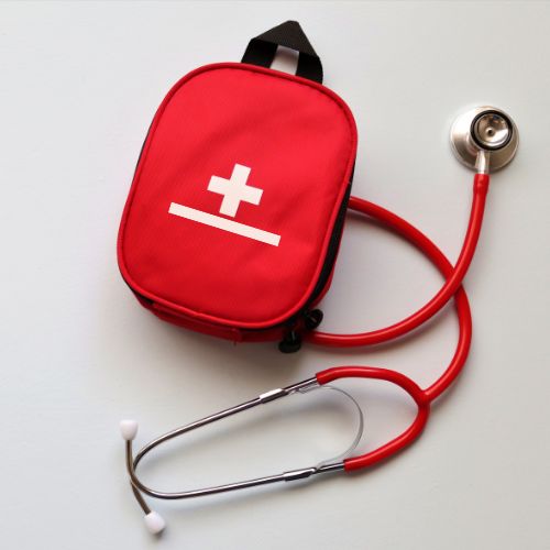 Red stethoscope and first aid kit