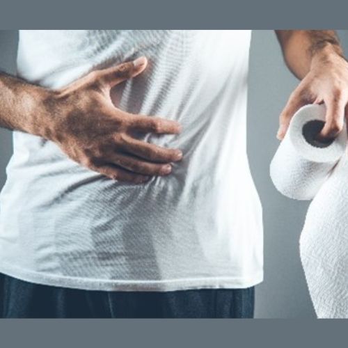 a man with one hand on his abdomin and the other holding a toilet roll