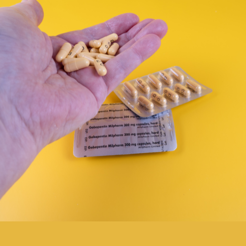 Person holding a number of gabapentin tablets in their hand