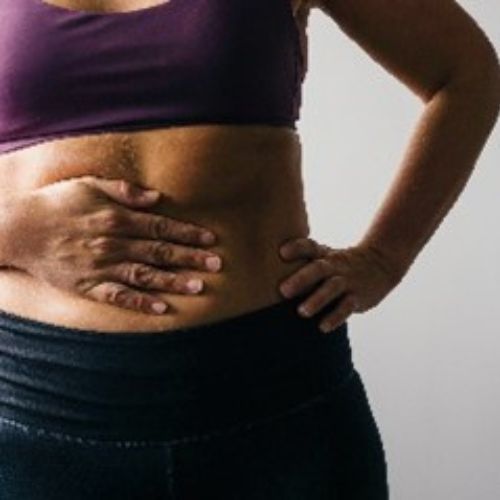 lady with one hand on her abdomin and one on her hip