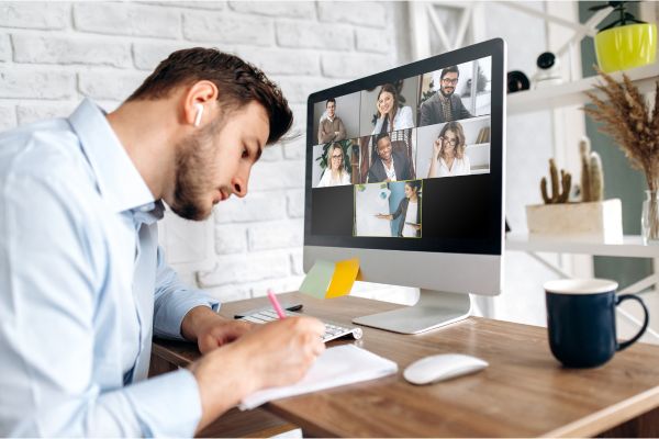 Person sitting at a desktop computer. He is in a group video call