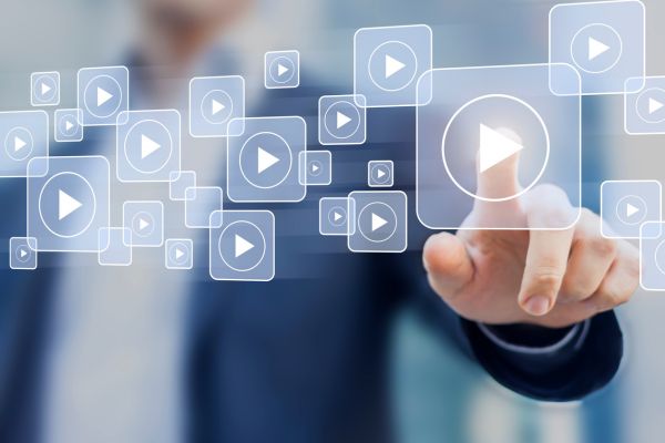 A man clicking a graphic of a play button out of a number of play button graphics