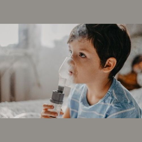 A child using an inhaler with a spacer