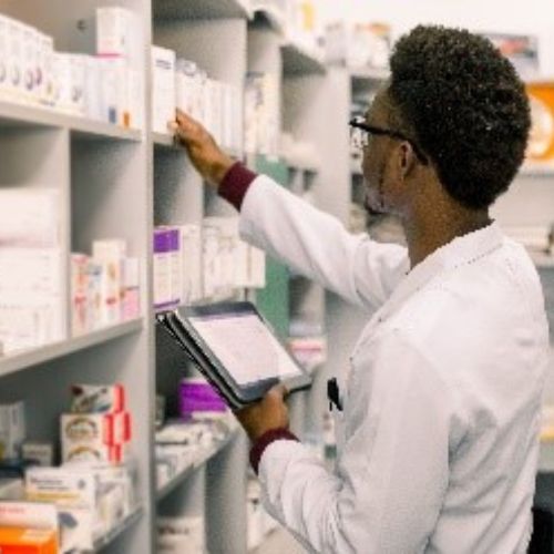 pharmacist picking medicines off a shelf