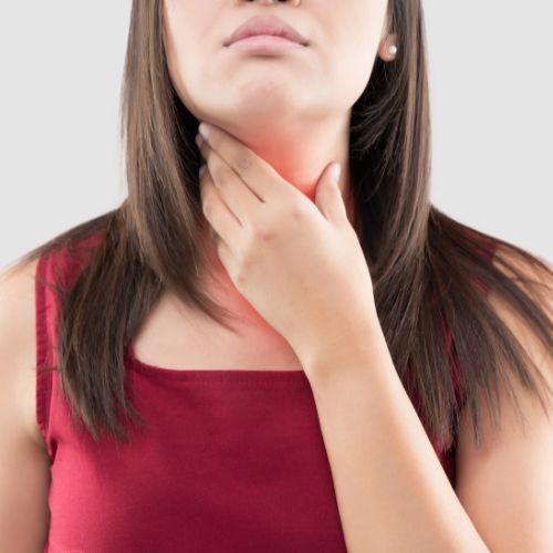 woman with a sore throat clutching her throat