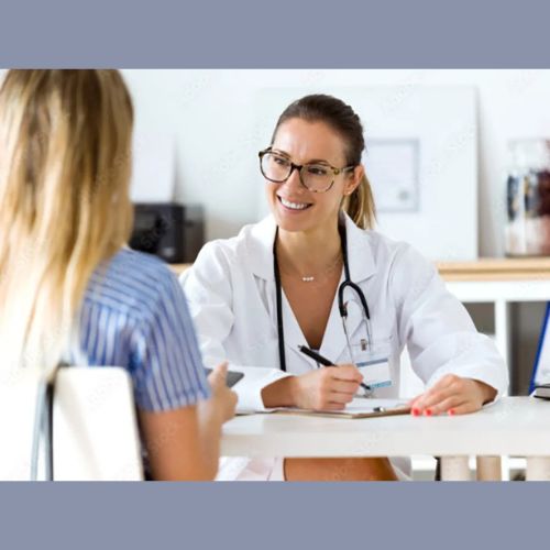 Female doctor smiling and discussing health concerns with a patient during a consultation.
