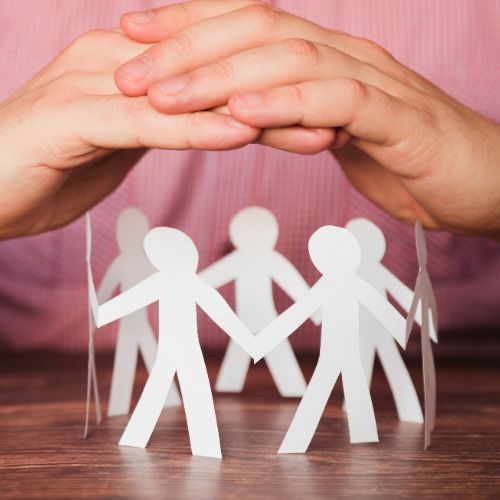 hands placed over a paper cut out of people holding hands
